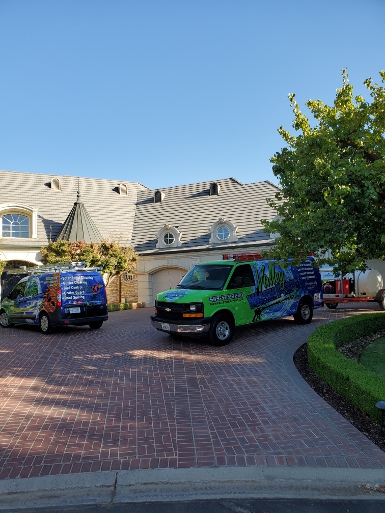 Two Valley Wash Pros service vans parked in the driveway of a tile roof home