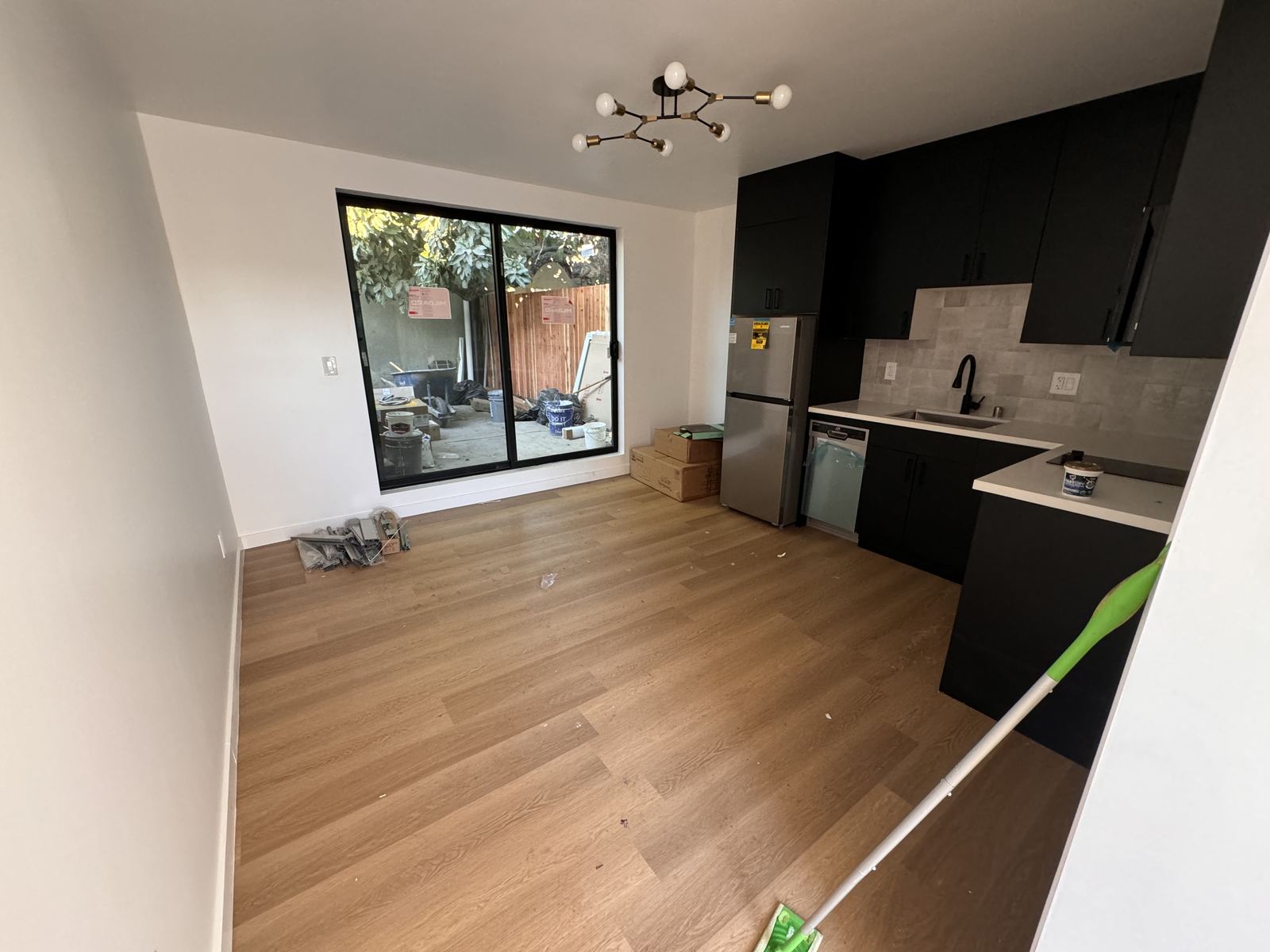 Newly finished interior being cleaned after construction with a window-cleaning pole at the glass