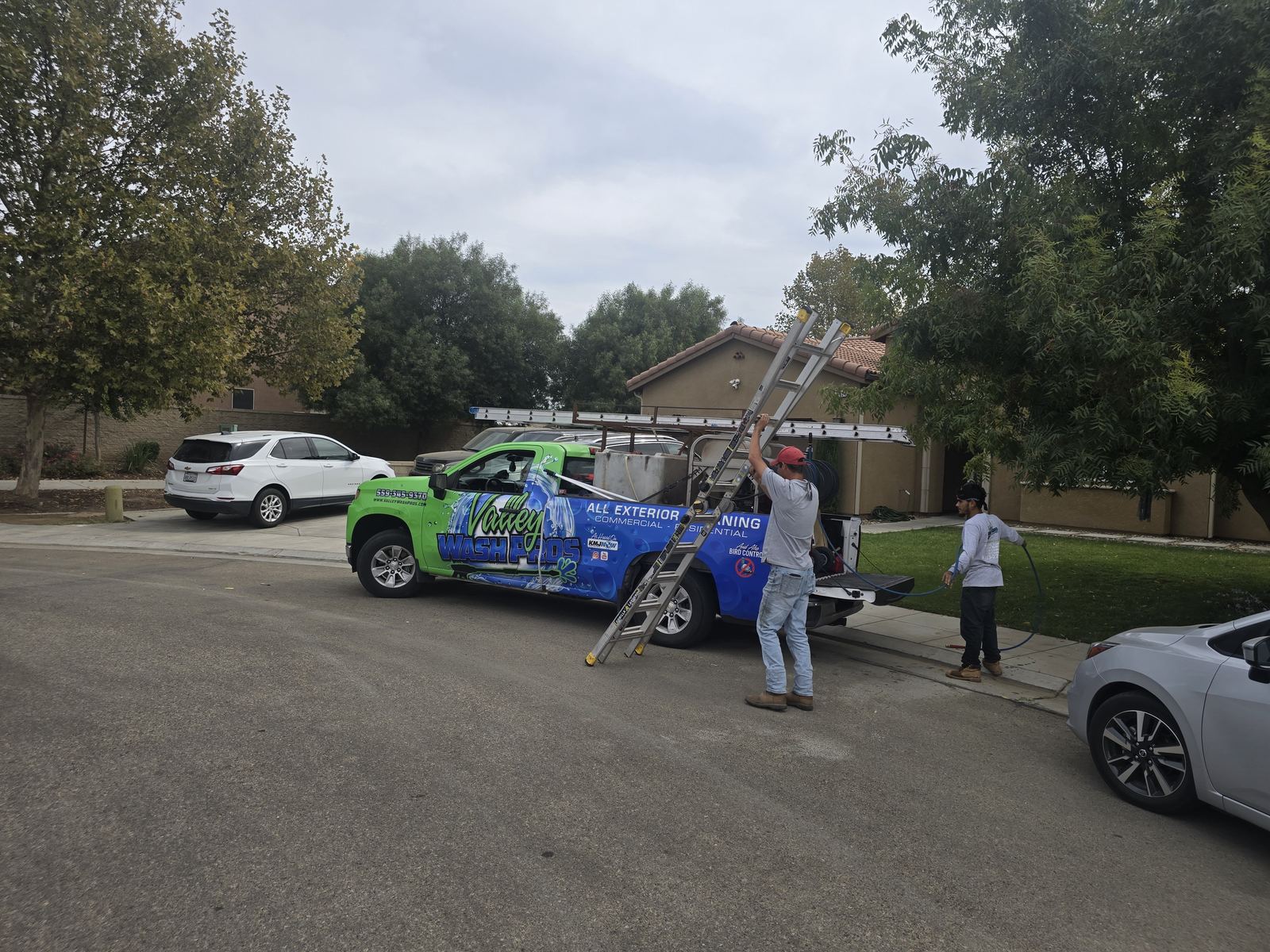 Green and blue Valley Wash Pros trucks parked with the crew unloading equipment before a Central Valley wash route