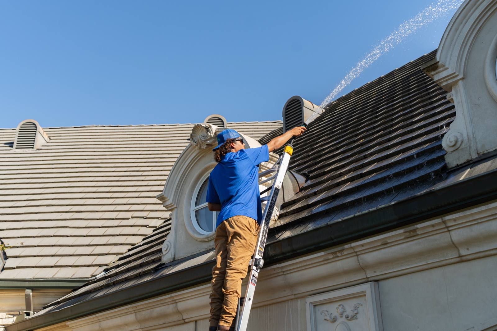 Technician cleaning rooftop solar panels